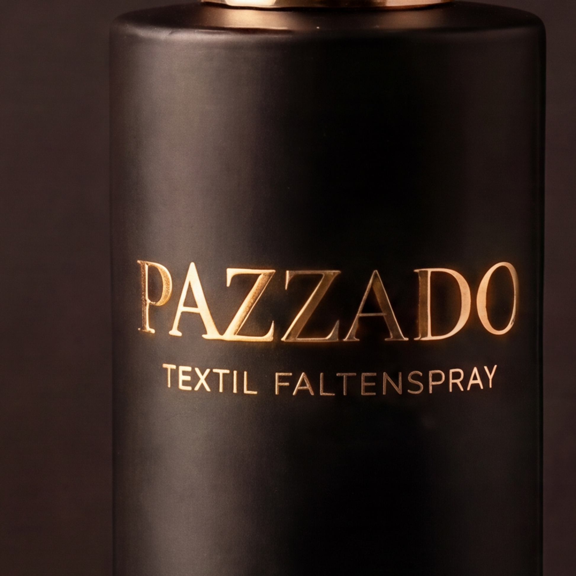 Nahaufnahme der goldenen Prägung PAZZADO Textil Faltenspray auf dem mattschwarzen Glas.